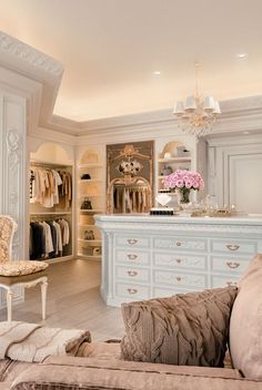 a room with white furniture and chandelier