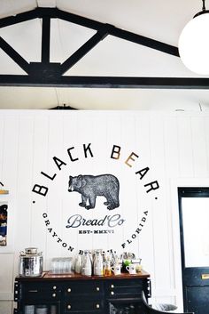 a black bear bar is shown in the corner of a room with white walls and wood beams