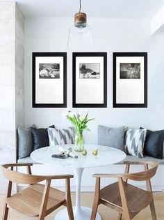 three black and white pictures hang on the wall above a dining room table