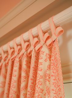 an orange and white curtain hanging from a window