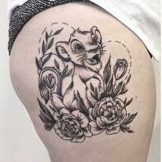 a woman's thigh with an elephant and flowers tattoo on it