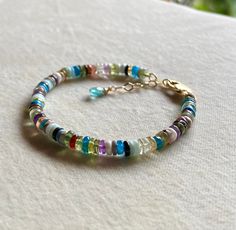 This is a rainbow of gemstones on your wrist which will brighten any day; it is lovely on it's own or stacked with other bracelets and bangles.  Assembled of a huge variety of natural untreated gemstones, such as Peridot, Amethyst, Topaz, Citrine, Lemon Quartz, Tourmaline, Opal, Turquoise, Malachite etc.  with a hand faceted paraiba colored Apatite briolette fastened to the end of the bracelet. Clasp and all other metal are of very high quality 14k gold filled material originating from the USA. Multi Gemstone Bracelet, Bracelet Rainbow, Rainbow Gemstones, Rainbow Bracelet, Sky Blue Topaz, Lemon Quartz, Nature Bracelets, Beautiful Gift Boxes, Gemstone Bracelet