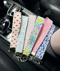 six keychains with hearts and flowers on them are attached to a car steering wheel