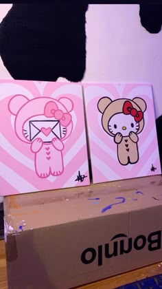 two hello kitty paintings are sitting on top of a box