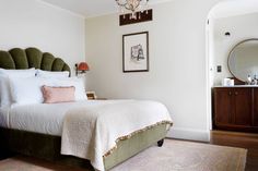 a bedroom with a bed, chandelier and pictures on the wall above it