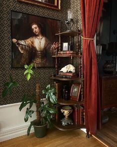 a living room with a painting on the wall and a potted plant in front of it