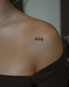 a woman's shoulder with the number forty - four tattoo on her left arm