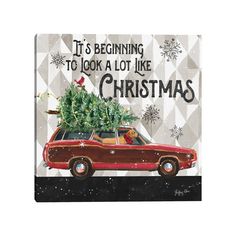 a red car with a christmas tree on the roof and words saying it's beginning to look a lot like christmas