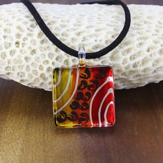 HANDMADE GLASS PENDANT  - This beautiful glass pendant necklace is made from hand blown glass, hand painted in warm yellow, orange and red colours with a black enamel painted back. ♥ TRADITIONAL CRAFT - Each individual piece of glass is hand-painted and crafted using traditional lamp work and fusing techniques to combine metallic textures and vibrant colours. Every piece of our jewellery is unique, and because it is handmade the designs and patterns may vary slightly from those in the photos. ♥ Abstract Jewelry, Square Pendant, Glass Pendant Necklace, Statement Pendant, Black Enamel, Hand Blown Glass, Leather Cord, Glass Pendants, Faux Suede