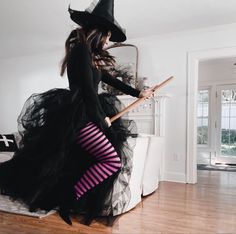 a woman in a witch costume holding a broom