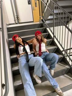 two young women sitting on the steps of a building wearing red hats and jeans with ties