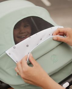 a woman holding onto the side of a baby stroller with her hand on it