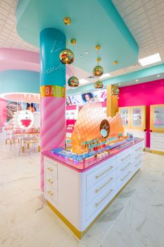 an ice cream shop with pink, blue and yellow decorations on the ceiling is brightly lit