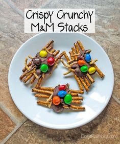 a white plate topped with pretzels and m & m sticks covered in candy