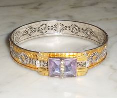 "This listing is for a JJ White Pat 1933576 Bangle Bracelet with one large Purple Stone and 6 mini clear stones )on a bar across the purple stone) mounted on Gold & Silver Tone Metal. I do not believe the metal is pure, only colored, but it does not attract the magnet I have. This measures 1/2 inch wide and this is approx 7 inches around the inside. This is Signed \"JJ W Pat 1933576\" on the inside of the bracelet.  See pics." Art Deco Hallmarked Bracelet For Anniversary, Formal Silver Jeweled Bracelet, Silver Jeweled Bracelet For Formal Occasions, Vintage Bangle Bracelets With Diamond Accents, Silver Art Deco Bracelets With Hand Set Details, Vintage Diamond Accented Bangle Bracelets, Purple Jeweled Jewelry For Anniversary, Vintage Bracelets With Diamond Accents As Gift, Vintage Purple Bangle Jewelry