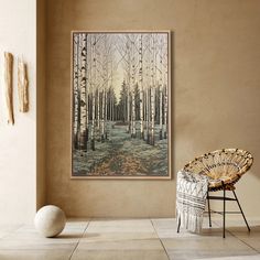 a painting hanging on the wall next to a wicker chair in a living room