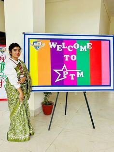 a woman standing in front of a welcome sign