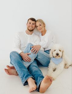 a man and woman sitting on the floor with their dog