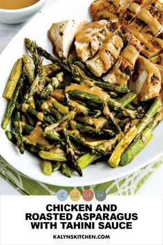 grilled chicken and roasted asparagus with tahini sauce on a white plate