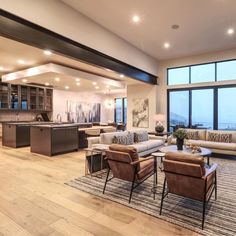 a living room filled with furniture next to a large open kitchen and dining room area