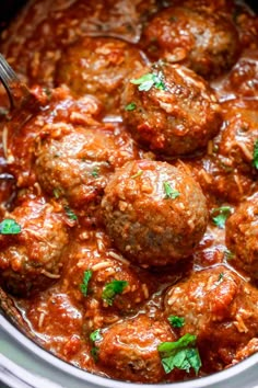 meatballs and sauce in a slow cooker with a spoon sticking out of it