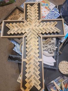 a cross made out of wood with words written on it and other items around it