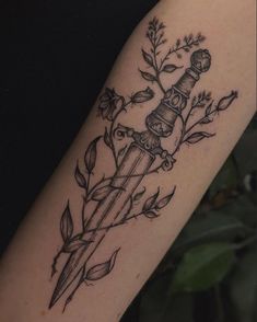 a tattoo on the arm of a woman with a knife and flowers around her neck