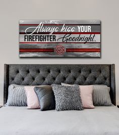 a bedroom with a bed, pillows and a large sign on the wall above it that says always tie your firefighter goodnight