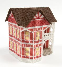 a small red and white house with a brown roof on a white tablecloth background