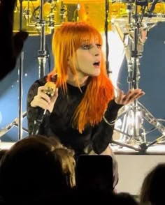 a woman with red hair is on stage