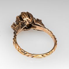 a gold ring with a dragon head on it's side, sitting on a white surface