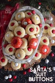 a platter filled with cookies and candy on top of a table next to a christmas tree