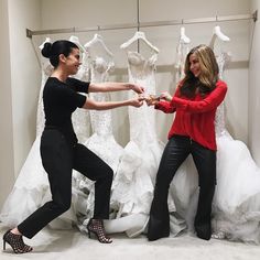 two women standing in front of wedding dresses