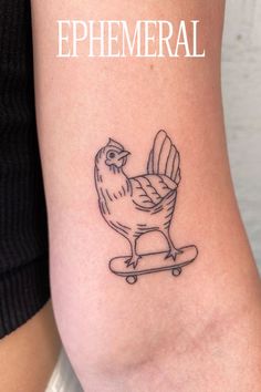 a tattoo on the arm of a woman with a rooster riding a skateboard