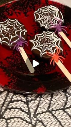 two spider - web cookies are on a plate with toothpicks in the shape of bats