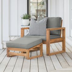 a chair and ottoman on a porch with white walls, wood flooring and potted plants