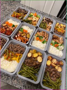 several trays filled with different types of food on top of a granite countertop