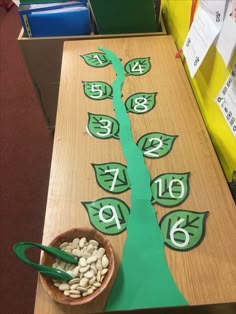 a wooden table topped with lots of green paper cut out to look like a tree