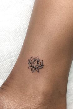 a small tattoo on the ankle of a woman's foot with a lotus flower