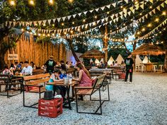 people are sitting at picnic tables under lights