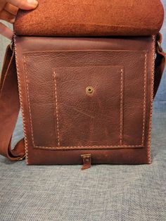 Rustic Brown Leather Satchel This particular bag is SOLD. We are happy to make you a similar one Practical purse, handbag, cross body, tablet, unisex, messenger, or shoulder bag. This bag is made from a rustic kodiak tanned leather. It has been treated with oils and waxes to make it durable and waterproof. It is hand stitched with nylon waxed thread. The stress points are reinforced with rivets and the strap is adjustable between one shoulder and across the body. The bag measures roughly 10 in b Artisan Handmade Brown Satchel, Brown Waxed Finish Shoulder Satchel, Distressed Brown Waxed Satchel Bag, Brown Leather Satchel With Vegetable-tanned Details, Distressed Brown Leather-lined Satchel Bag, Brown Leather Satchel, I Love Bees, Walk In The Woods, Rustic Brown