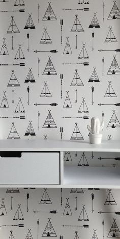 a white table topped with a shelf filled with cups and vases next to a wallpaper