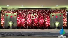 the stage is decorated with red and white flowers, candles, and decorations for an event