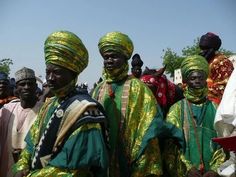 a group of people standing next to each other wearing green and gold clothing on top of a field