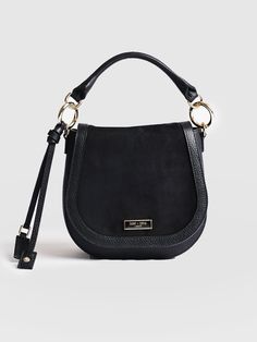 A classic saddle bag in black, made with the softest Italian leather and suede for a chic look and feel. Handmade in our studios in Europe in small numbers to guarantee the perfect finish. Durable and water resistant, this is a classic style you can wear in years from now. Finished with golden hardware and given a refined polish. A small occasion bag that's perfect for work or weekends. Leather Saddle Bag With Detachable Handle For Work, Chic Shoulder Bag With Suede Lining For Work, Black Saddle Bag With Gold-tone Hardware, Black Saddle Bag With Gold-tone Hardware For Everyday, Black Saddle Bag With Gold-tone Hardware For Work, Chic Satchel Shoulder Bag With Suede Lining, Chic Leather Saddle Bag For On-the-go, Black Leather Bag With Suede Lining, Luxury Black Saddle Bag In Soft Leather