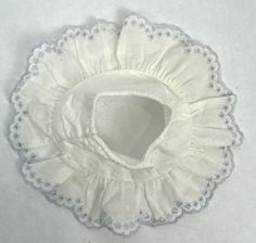 a white doily with scalloped edges on a white tablecloth background,