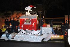 a parade float with musical notes on it's side and people waving to the crowd