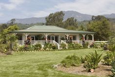 the house is surrounded by lush greenery and mountains in the backgrouund