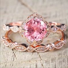 a close up of a ring with a pink stone in the center and diamonds around it