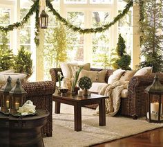 a living room filled with lots of furniture and christmas trees in the window sill